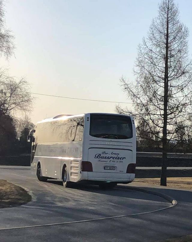 Hvit turbuss kjører på vei